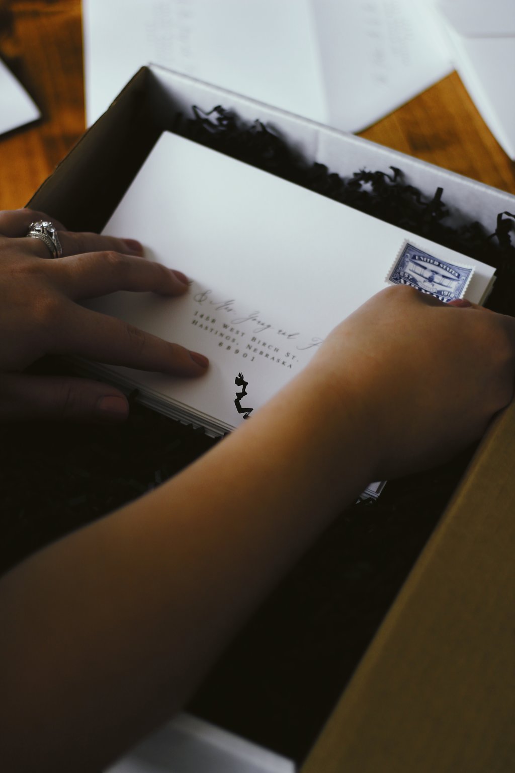 girl putting a stamp on an invitation envelope